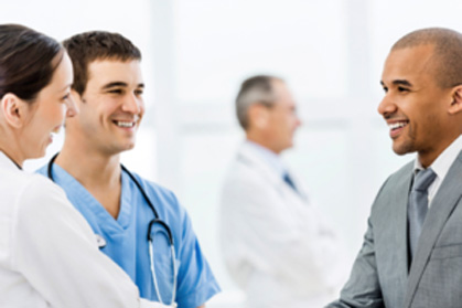 Three U.S. Healthtek staff members in a group talking and smiling